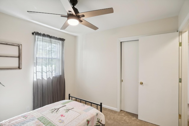 bedroom with light carpet, a closet, and ceiling fan