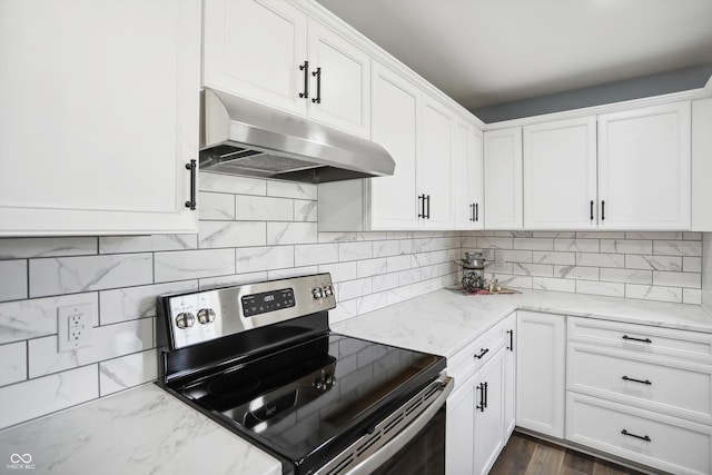 kitchen with electric stove, under cabinet range hood, white cabinetry, and light stone counters