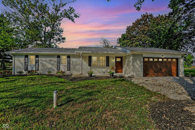 ranch-style home with an attached garage, a front yard, driveway, and brick siding