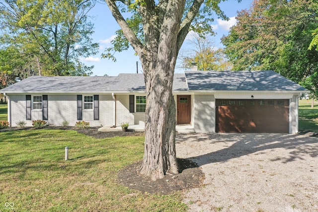 ranch-style home featuring an attached garage, a chimney, driveway, brick siding, and a front lawn