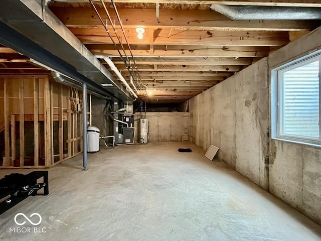 below grade area featuring gas water heater, heating unit, and a water softener