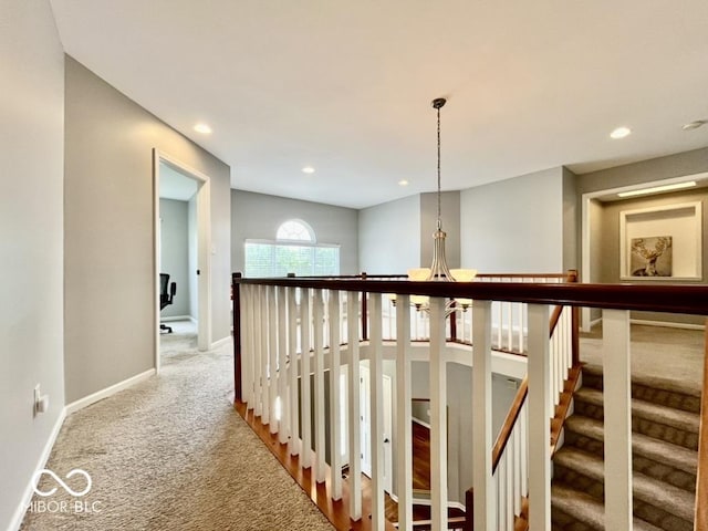 corridor featuring carpet floors, recessed lighting, baseboards, an upstairs landing, and a chandelier