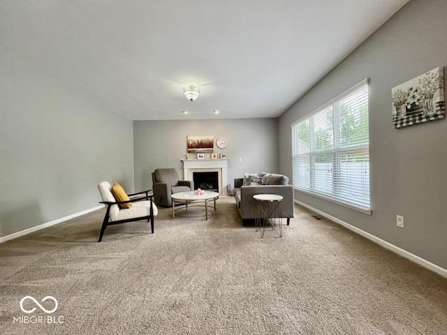 carpeted living room with baseboards and a fireplace