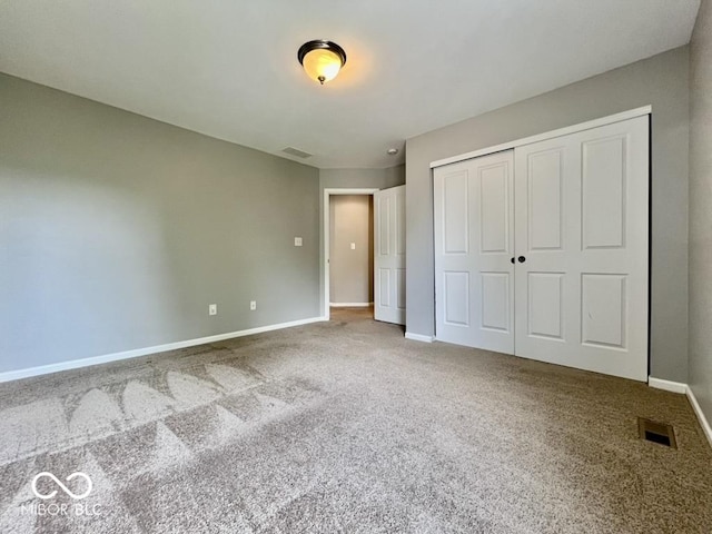 unfurnished bedroom featuring baseboards, carpet, and a closet