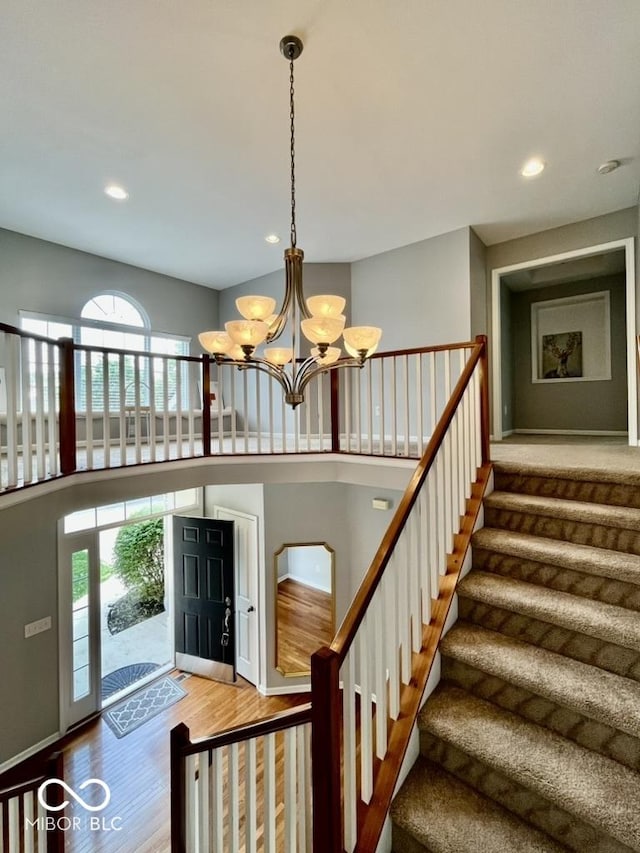 foyer with wood finished floors, a chandelier, stairway, and recessed lighting