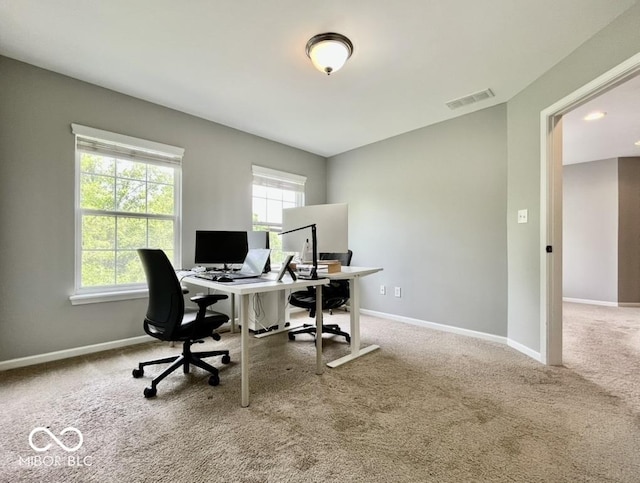 carpeted office space featuring plenty of natural light and baseboards
