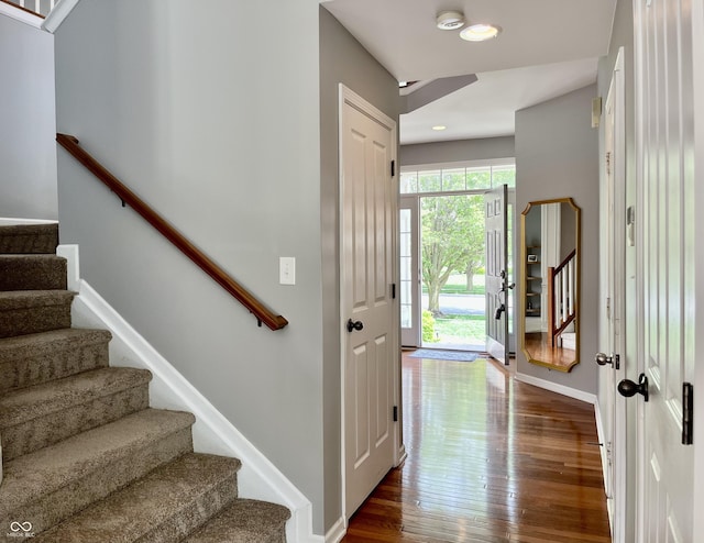 entryway featuring stairway, dark wood-type flooring, baseboards, and recessed lighting