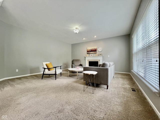 living room featuring carpet, a fireplace, and baseboards