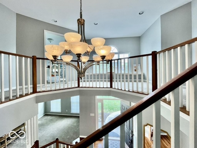 stairs with a chandelier, carpet, and recessed lighting