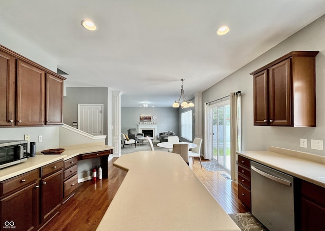 kitchen featuring stainless steel appliances, dark wood-style floors, a fireplace, light countertops, and recessed lighting