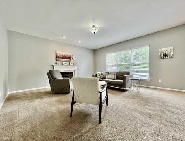 carpeted living room featuring baseboards and a fireplace