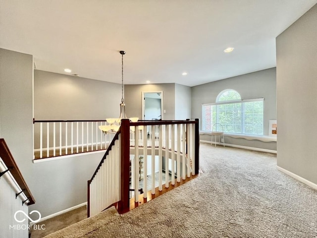 hallway featuring an upstairs landing, carpet floors, baseboards, and recessed lighting