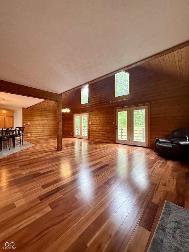 1340 Apache Trl, Martinsville, IN 46151 - unfurnished living room with wooden walls, wood-type flooring, vaulted ceiling, and a chandelier