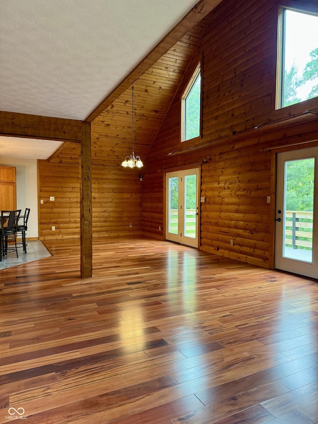 1340 Apache Trl, Martinsville, IN 46151 - unfurnished living room featuring a chandelier, high vaulted ceiling, wood-type flooring, and wood walls