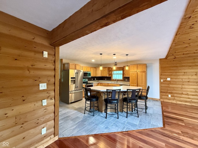1340 Apache Trl, Martinsville, IN 46151 - kitchen with stainless steel appliances, light countertops, a kitchen island, a breakfast bar area, and light wood-style flooring
