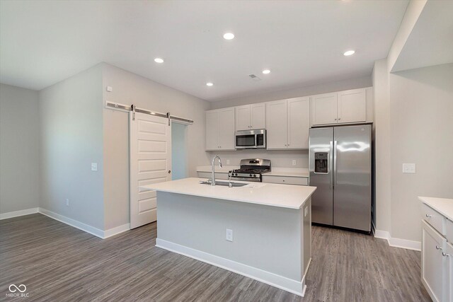 9570 Beckett St, Avon, IN 46123 - kitchen with stainless steel appliances, a sink, a barn door, wood finished floors, and light countertops