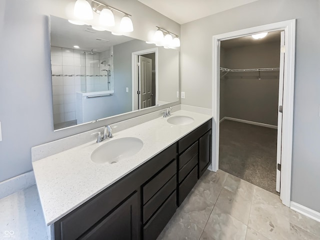 18230 Sandy Cove Ln, Westfield, IN 46074 - bathroom featuring double vanity, a spacious closet, tiled shower, tile patterned floors, and baseboards