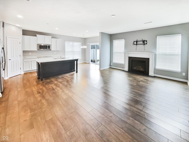 18230 Sandy Cove Ln, Westfield, IN 46074 - living room featuring light wood-style flooring, a fireplace with flush hearth, baseboards, and recessed lighting