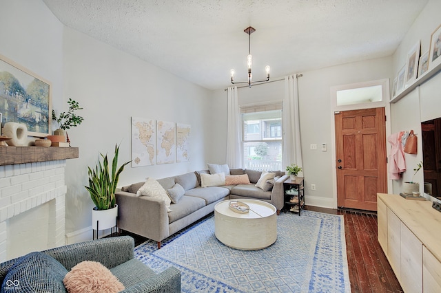 1009 Broadway St, Indianapolis, IN 46202 - living area with dark wood-style floors, a chandelier, baseboards, a brick fireplace, and a textured ceiling