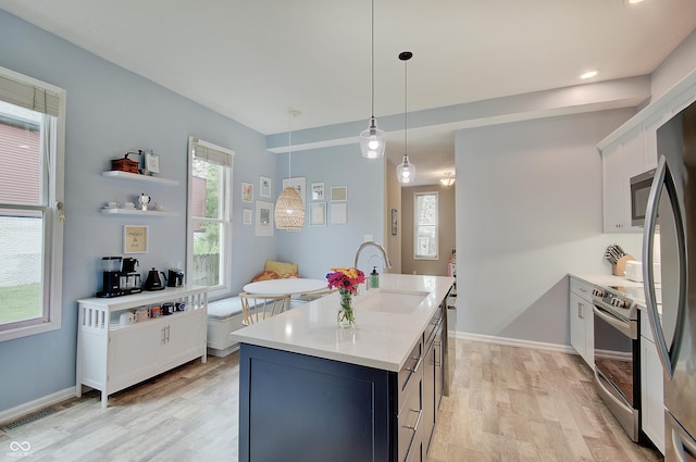 1009 Broadway St, Indianapolis, IN 46202 - kitchen featuring a sink, stainless steel appliances, light wood-style flooring, light countertops, and white cabinetry