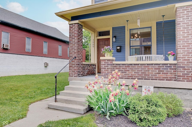 1009 Broadway St, Indianapolis, IN 46202 - doorway to property with a porch, brick siding, cooling unit, and a yard