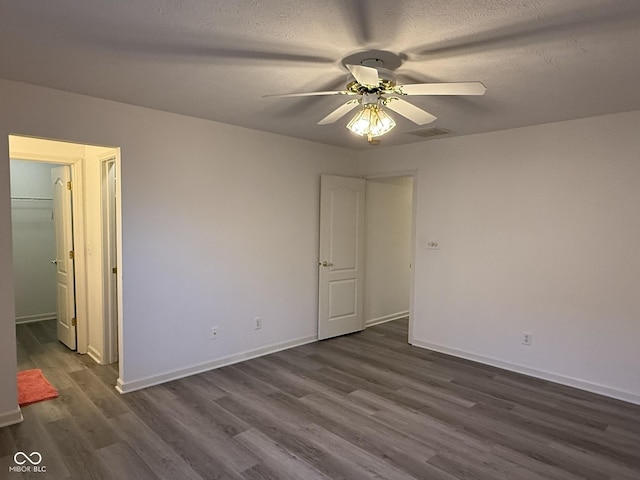 11523 Coastal Way, Indianapolis, IN 46229 - spare room featuring dark wood-style flooring, ceiling fan, baseboards, and a textured ceiling