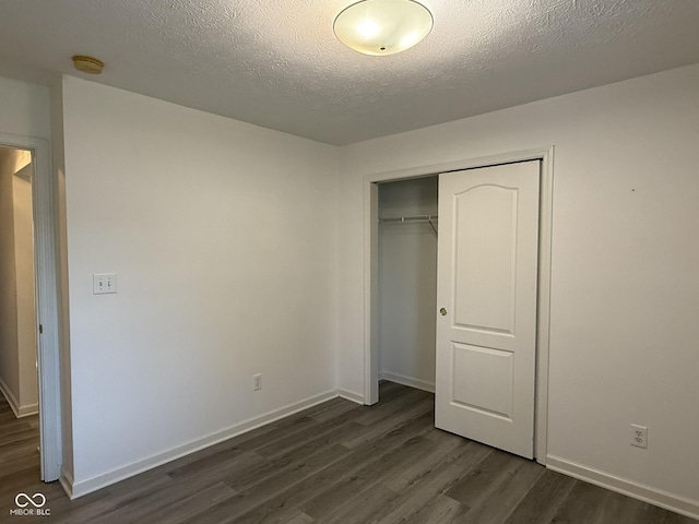 11523 Coastal Way, Indianapolis, IN 46229 - unfurnished bedroom featuring dark wood-style flooring, a closet, baseboards, and a textured ceiling