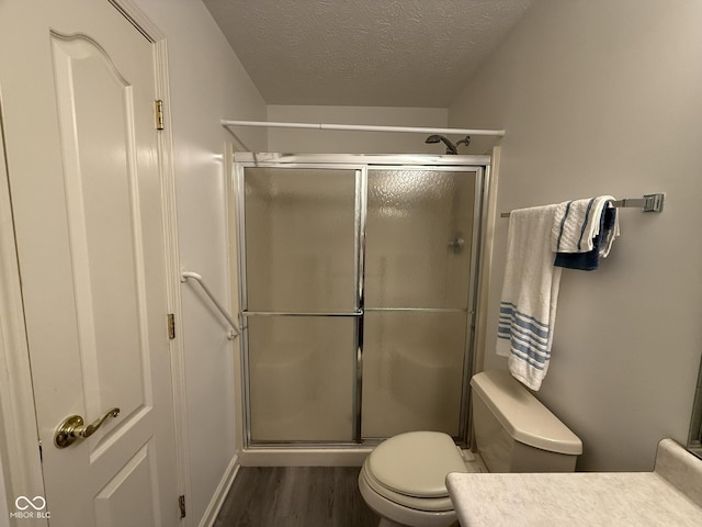 11523 Coastal Way, Indianapolis, IN 46229 - bathroom featuring wood finished floors, a stall shower, toilet, a textured ceiling, and vanity