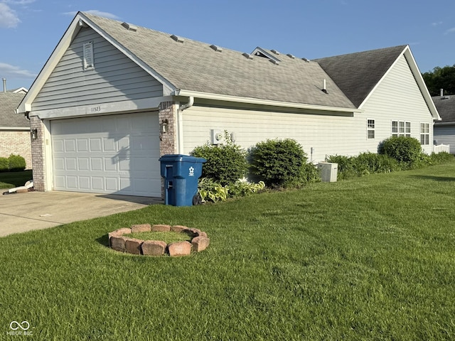 11523 Coastal Way, Indianapolis, IN 46229 - view of property exterior featuring driveway, a garage, a yard, a shingled roof, and brick siding
