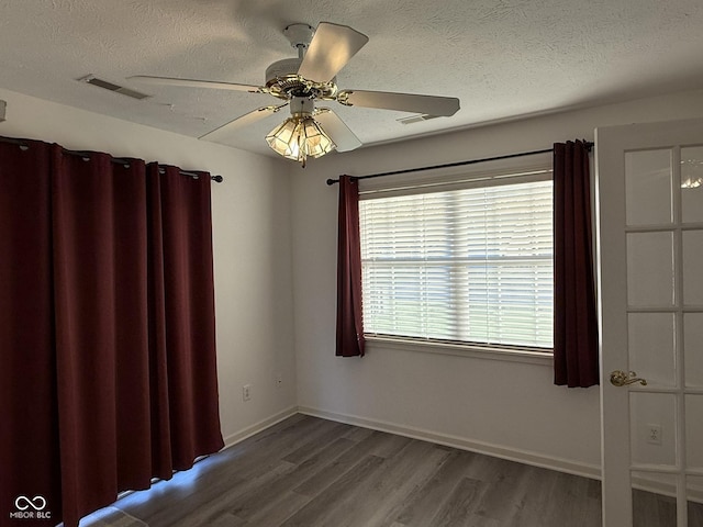 11523 Coastal Way, Indianapolis, IN 46229 - spare room featuring plenty of natural light, wood finished floors, a textured ceiling, a ceiling fan, and baseboards