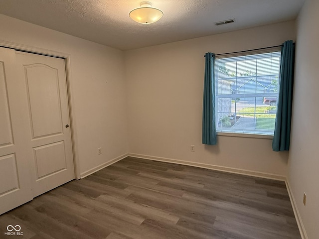 11523 Coastal Way, Indianapolis, IN 46229 - spare room featuring dark wood-style flooring, a textured ceiling, and baseboards