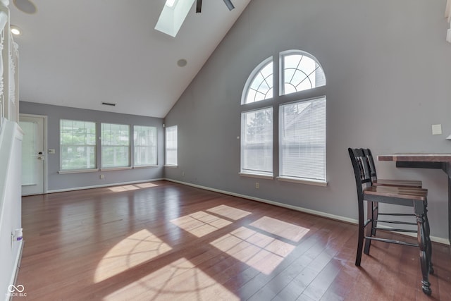 6542 E Edna Mills Dr, Camby, IN 46113 - unfurnished living room with high vaulted ceiling, a skylight, wood finished floors, and baseboards