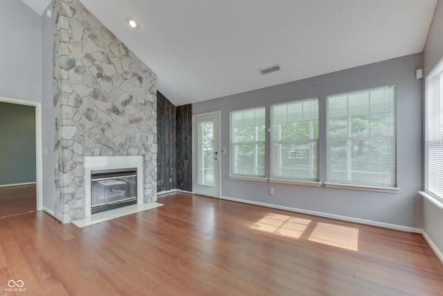 6542 E Edna Mills Dr, Camby, IN 46113 - unfurnished living room featuring vaulted ceiling, wood finished floors, a stone fireplace, and healthy amount of natural light