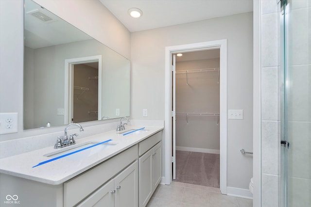 9604 Beckett St, Avon, IN 46123 - bathroom with tile patterned floors, a walk in closet, double vanity, and baseboards