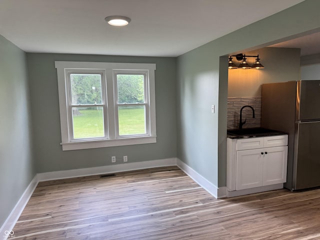 671 E Bethel Rd, Attica, IN 47918 - unfurnished dining area featuring a sink, light wood-style flooring, and baseboards