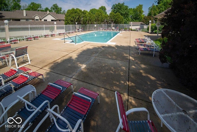community pool with fence and a patio