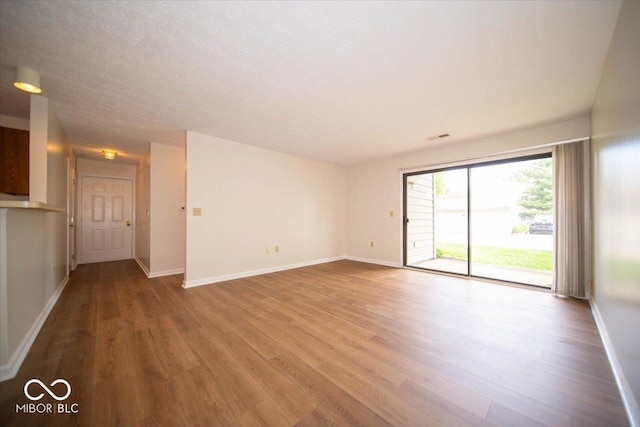 spare room featuring wood finished floors and baseboards