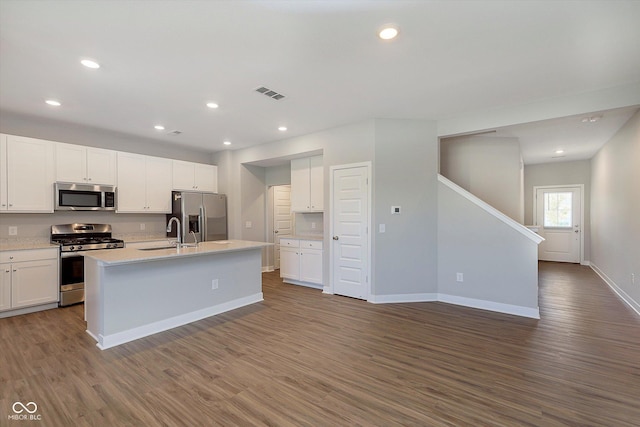1280 Newton St, Avon, IN 46123 - kitchen with appliances with stainless steel finishes, baseboards, dark wood finished floors, white cabinetry, and an island with sink