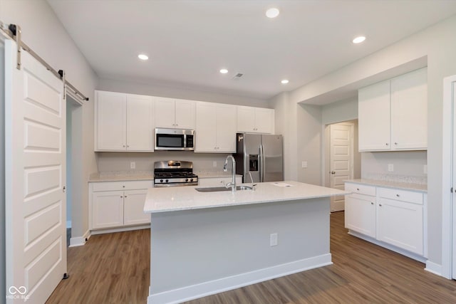 1280 Newton St, Avon, IN 46123 - kitchen with appliances with stainless steel finishes, a sink, a barn door, wood finished floors, and white cabinets