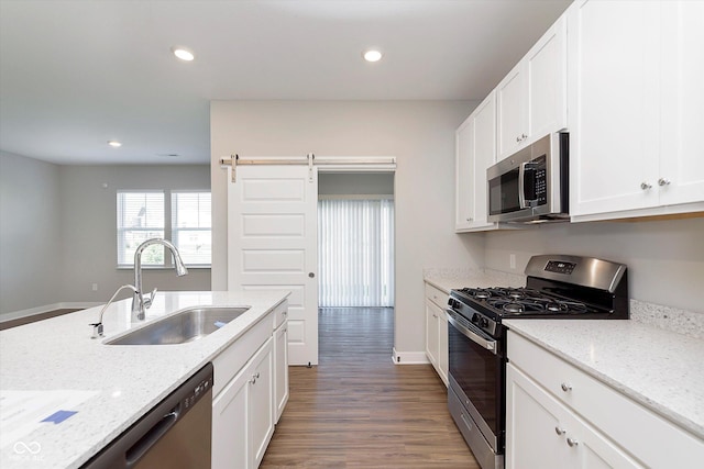 1280 Newton St, Avon, IN 46123 - kitchen featuring appliances with stainless steel finishes, a sink, wood finished floors, white cabinets, and light stone countertops