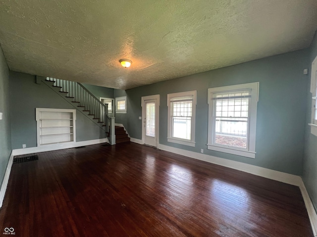 1137 W 34th St, Indianapolis, IN 46208 - unfurnished living room featuring a textured ceiling, wood finished floors, stairway, and baseboards
