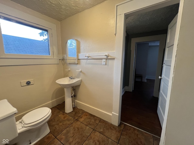 1137 W 34th St, Indianapolis, IN 46208 - bathroom featuring a textured ceiling, toilet, tile patterned flooring, baseboards, and a sink