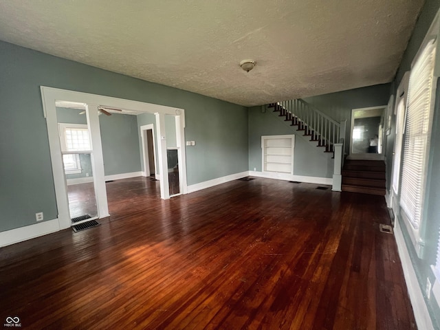 1137 W 34th St, Indianapolis, IN 46208 - unfurnished living room featuring hardwood / wood-style flooring, stairs, a textured ceiling, baseboards, and ceiling fan