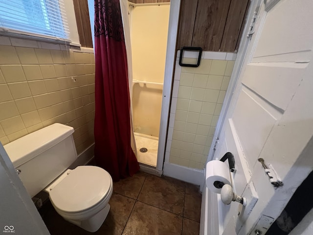 1137 W 34th St, Indianapolis, IN 46208 - bathroom with a shower stall, toilet, tile walls, and tile patterned flooring