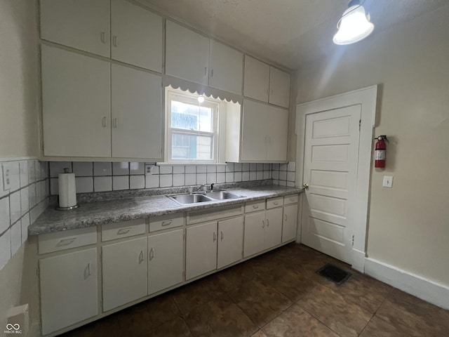 1137 W 34th St, Indianapolis, IN 46208 - kitchen featuring a sink, tasteful backsplash, white cabinets, baseboards, and light countertops