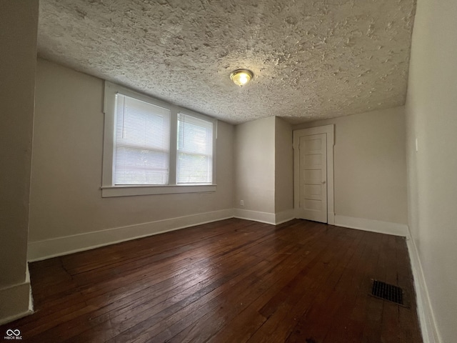 1137 W 34th St, Indianapolis, IN 46208 - empty room with dark wood-type flooring, baseboards, and a textured ceiling