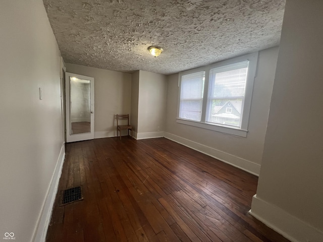 1137 W 34th St, Indianapolis, IN 46208 - unfurnished room featuring a textured ceiling, dark wood finished floors, and baseboards