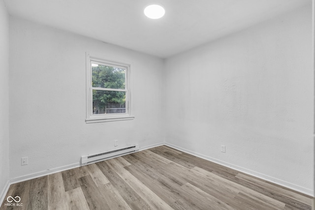 6017 Bluff Crest Ct, Indianapolis, IN 46217 - spare room featuring baseboard heating, wood finished floors, and baseboards