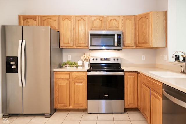 8317 Pine Branch Ln, Indianapolis, IN 46234 - kitchen featuring stainless steel appliances, a sink, light countertops, light brown cabinets, and light tile patterned floors