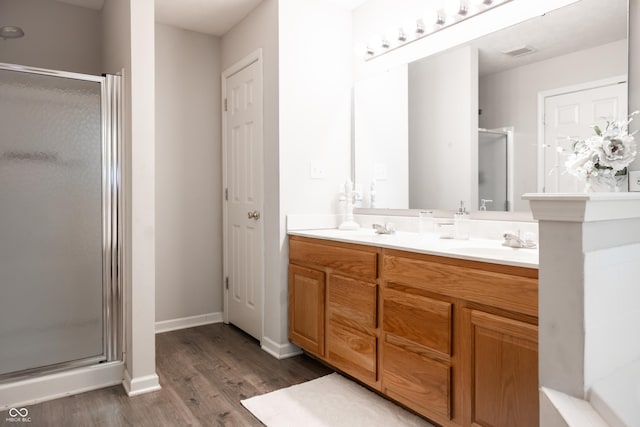 8317 Pine Branch Ln, Indianapolis, IN 46234 - bathroom featuring wood finished floors, a shower stall, double vanity, and baseboards